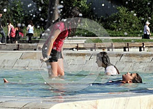 Kids play in a water of a fountain on a sunny summer day during summer break in Sofia, Bulgaria Ã¢â¬â june 15, 2012. Sunny weather c